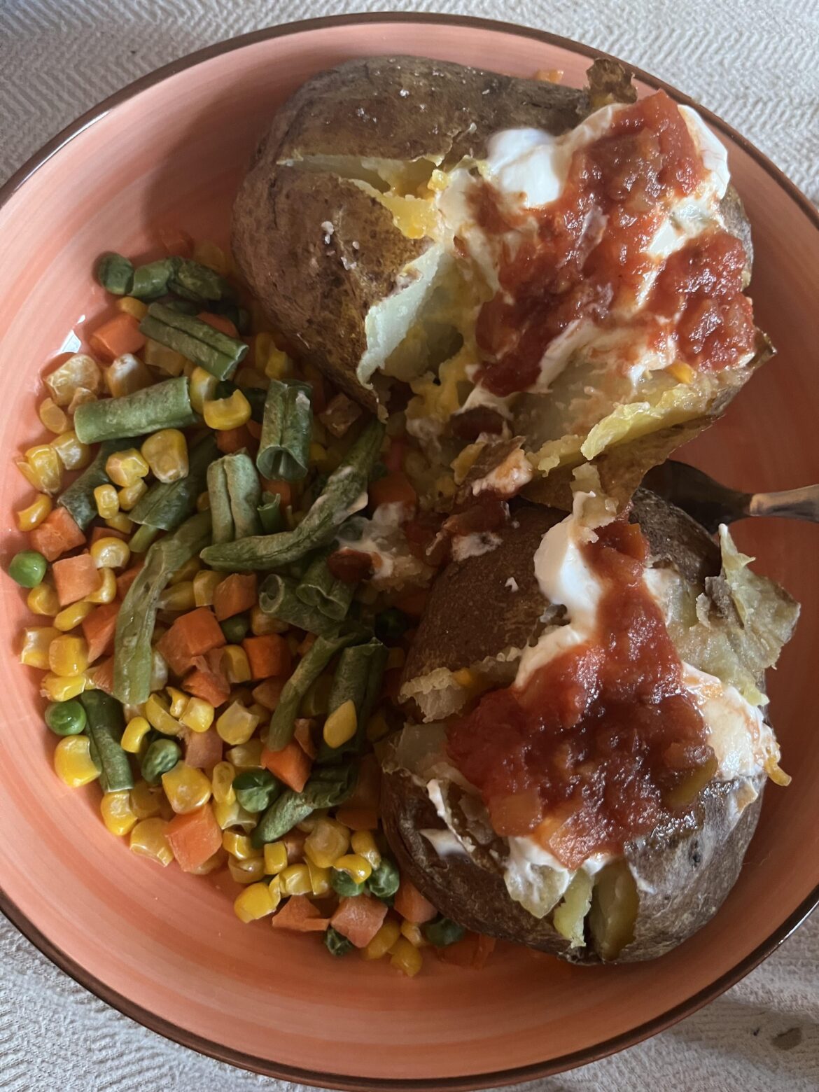 Currently pregnant, eating 2 baked potatoes with butter, cheese, sour cream, and salsa, with a side of mixed veggies