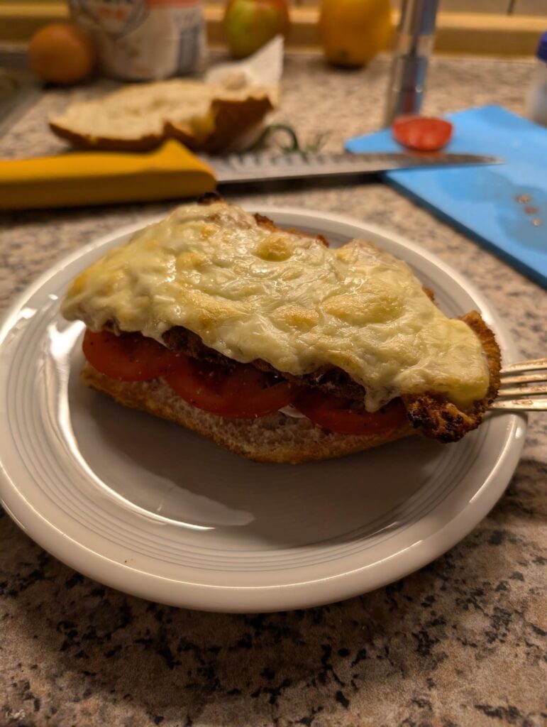 Turkey Schnitzel with Swiss cheese and tomatoes on a baguette bun
