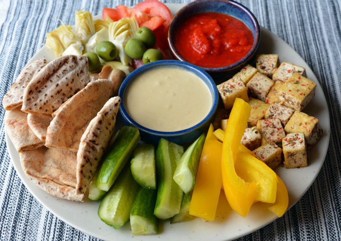466  cal (33 g protein) hummus plate with homemade harissa sauce, za' atar tofu (with crushed pink peppercorn) , olives, artichoke hearts, marinated mushrrom, tomato, bell pepper, pita, cucumber