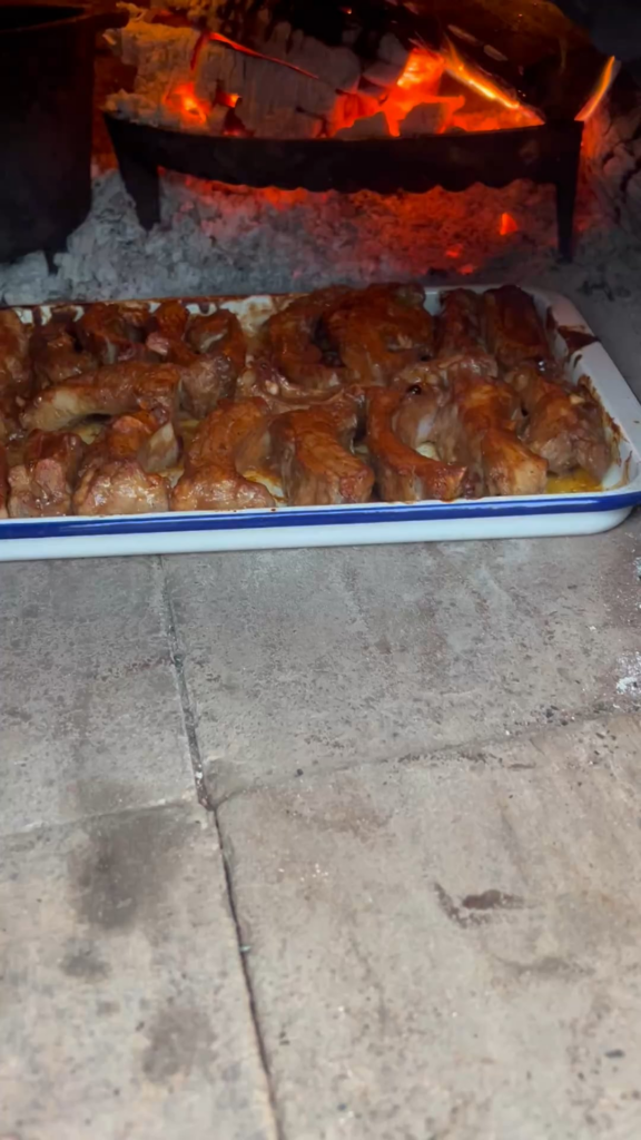 Spicy pork ribs cook in the wood fired cob oven.