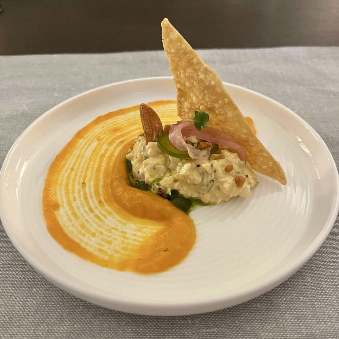 Egg salad, carrot cream, spinach puree, pickled onion, fried garlic and wonton crisp
