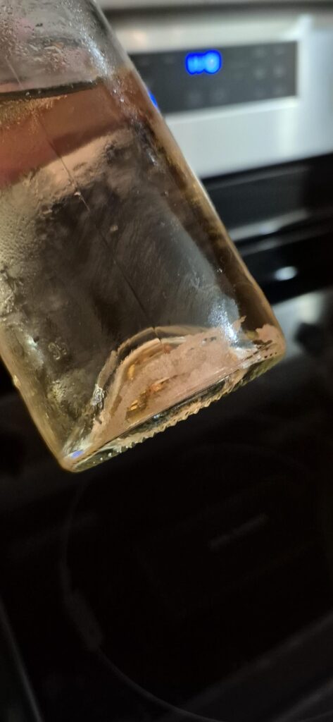 What is this in my wine? Just opened this a week ago and put it my fridge. Not sure if it was there before...Sorry for the bad pictures but my camera wouldnt focus through the glass.