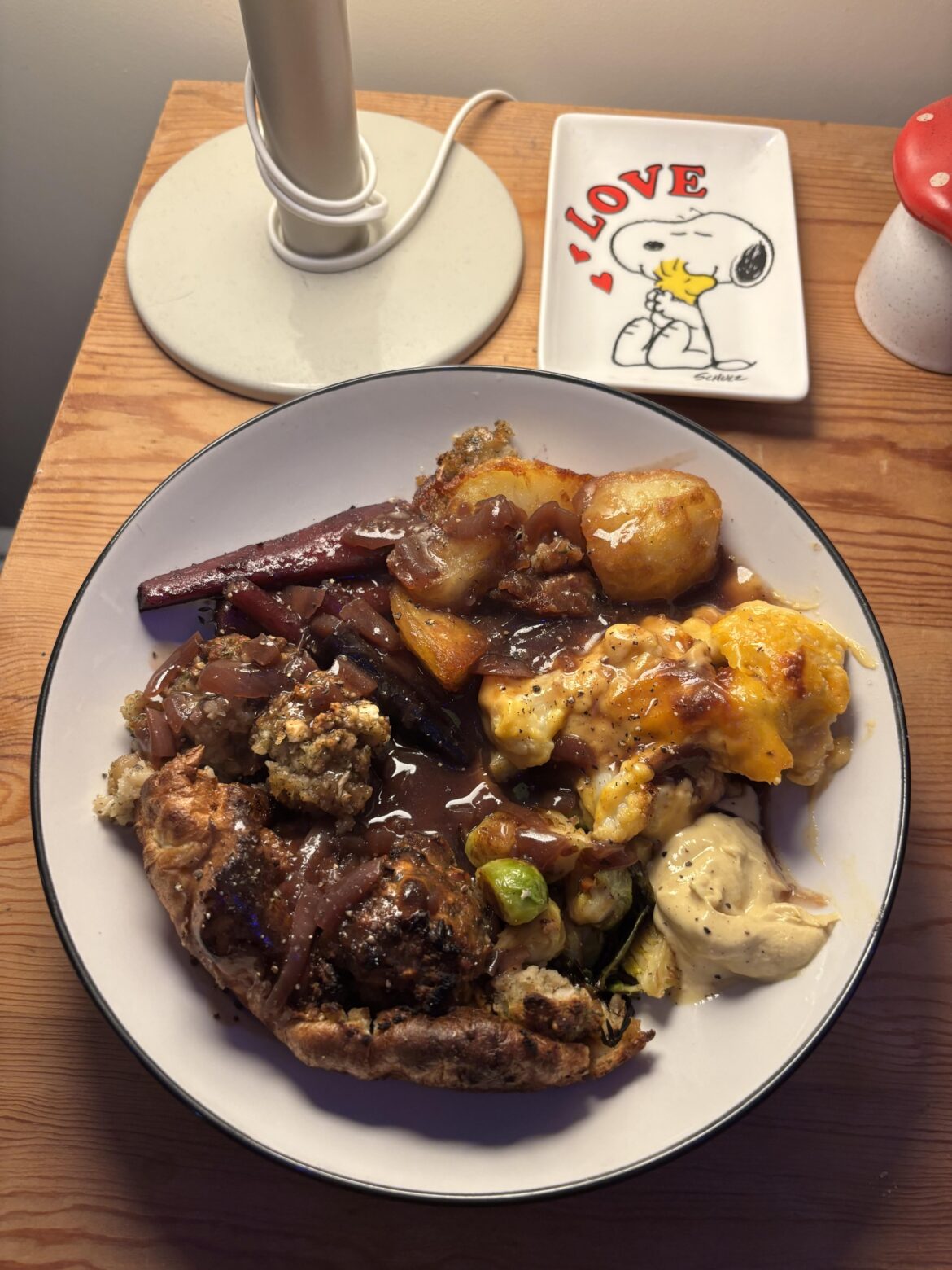 Vegetarian Christmas dinner featuring stuffing-in-the-hole, cauliflower cheese, purple carrots n parsnips in a maple glaze, garlic fried sprouts, and red-wine onion gravy.