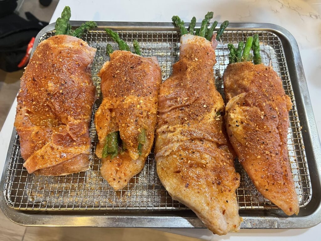 Asparagus and mozzarella wrapped in prosciutto and stuffed inside a chicken breast and then wrapped with prosciutto on the outside of the chicken breast, followed by a whiskey rub dry rub from Traeger