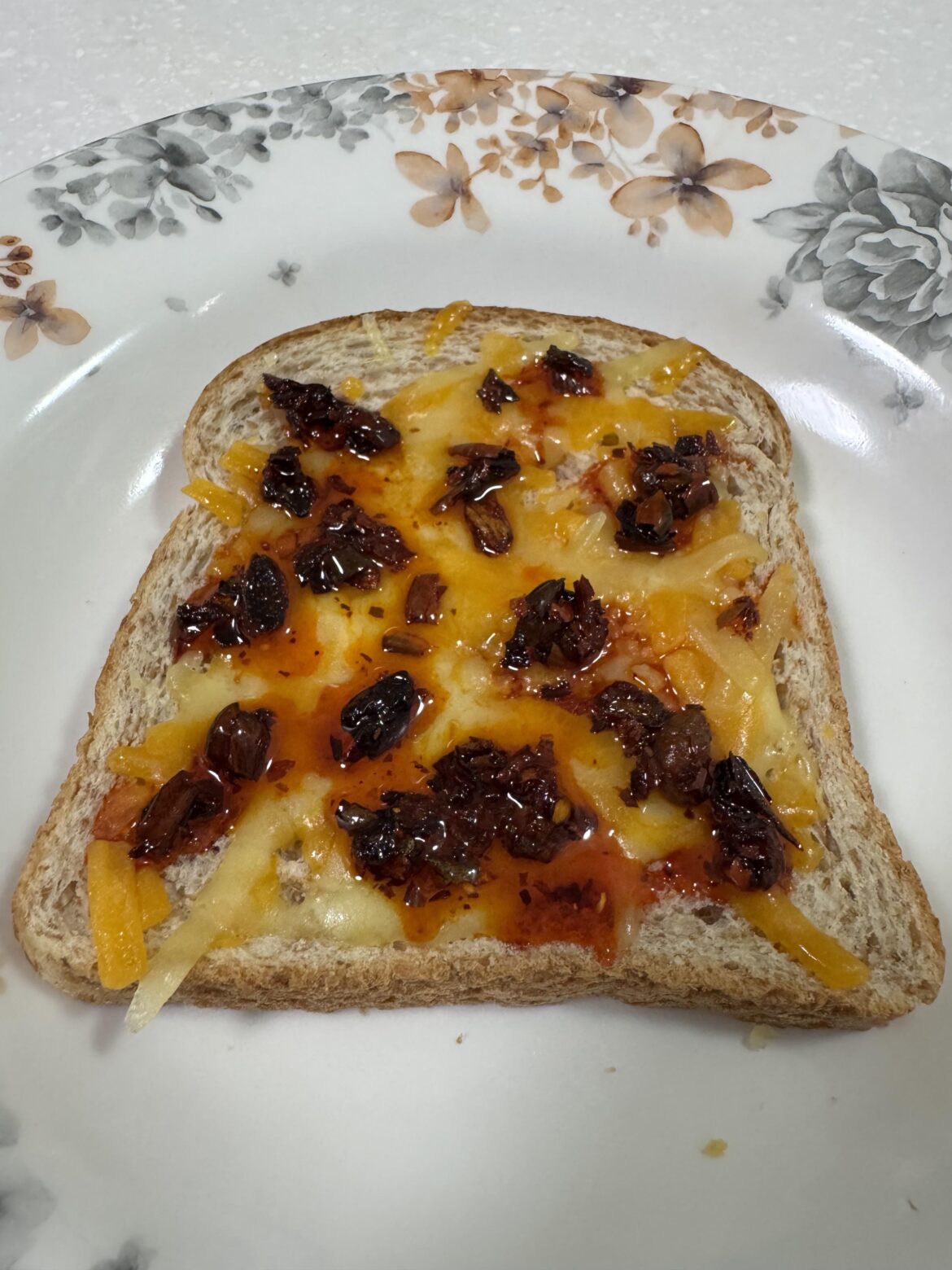 Stale bread with some leftover cheddar and chili crisp on top