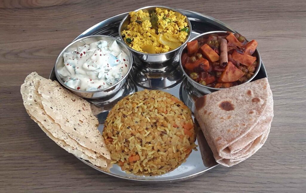 Veg Thali: Tofu Bhurji, Shakkarkandi Matar Masala, Masoor Dal Khichdi, and Cucumber Cashew Raita