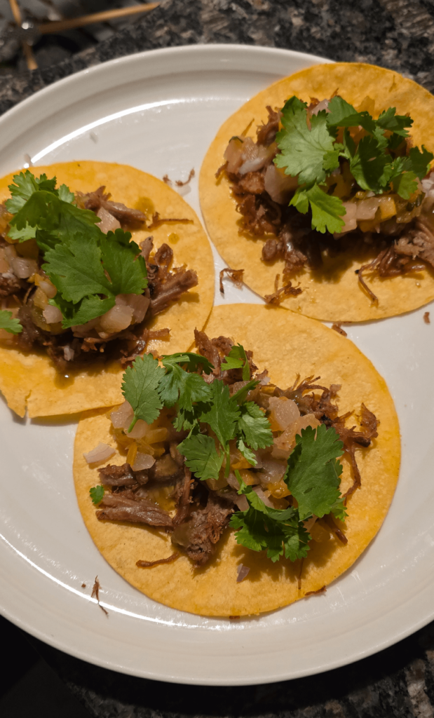 Pulled pork tacos with pineapple salsa, cholula green hot sauce