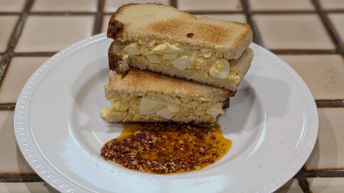 Egg salad sandwich with some spicy, crunchy chili onion oil for dipping