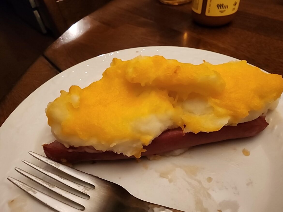 Hot dog sliced in half filled with mashed potatos covered in cheese and baked. I present, "The Weenie Puff"
