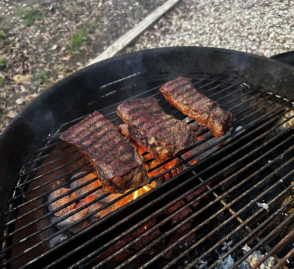Grilled Denver steak, corn on the cob, and charred Caesar salad.