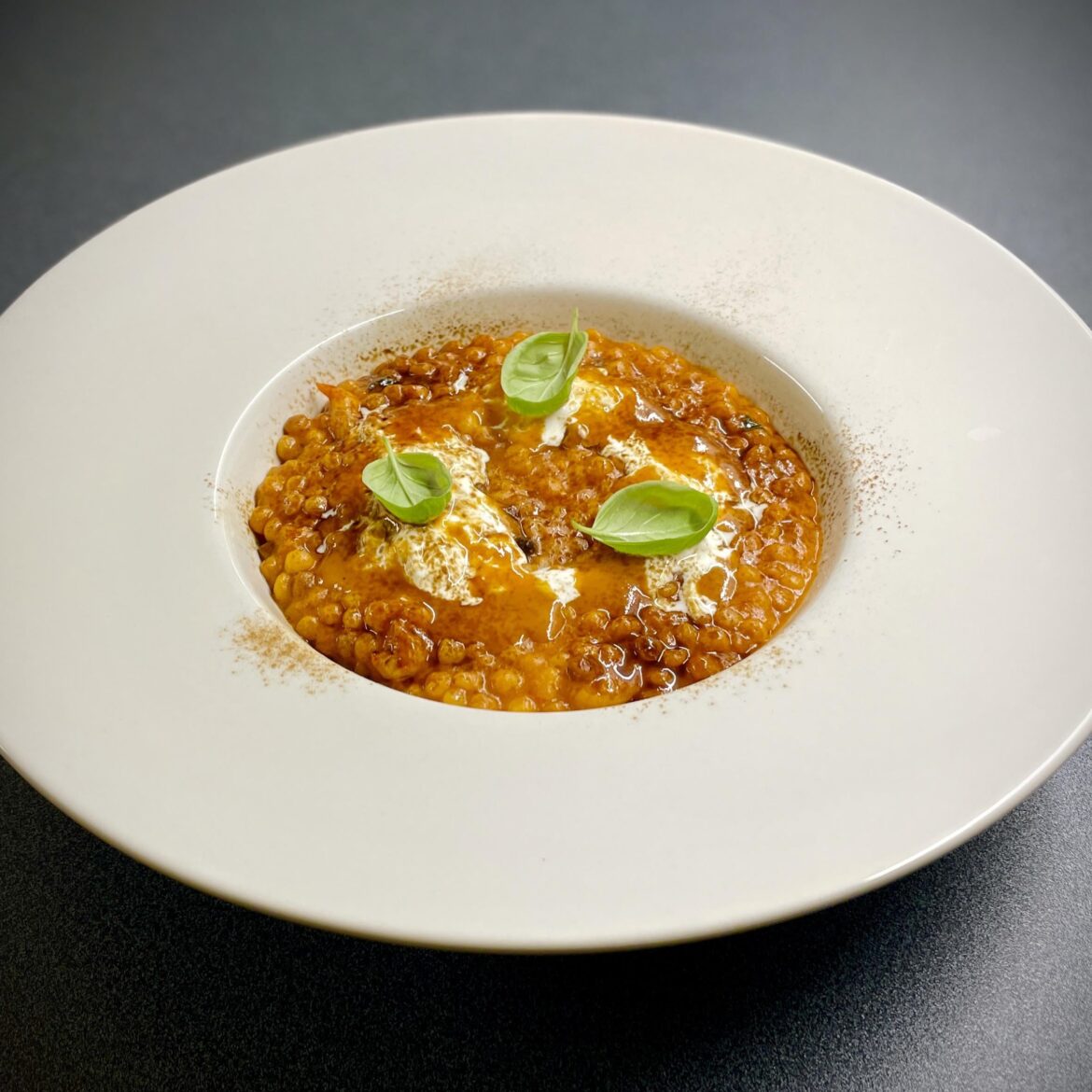 Fregula with prawns and their bisque, basil, stracciatella, licorice