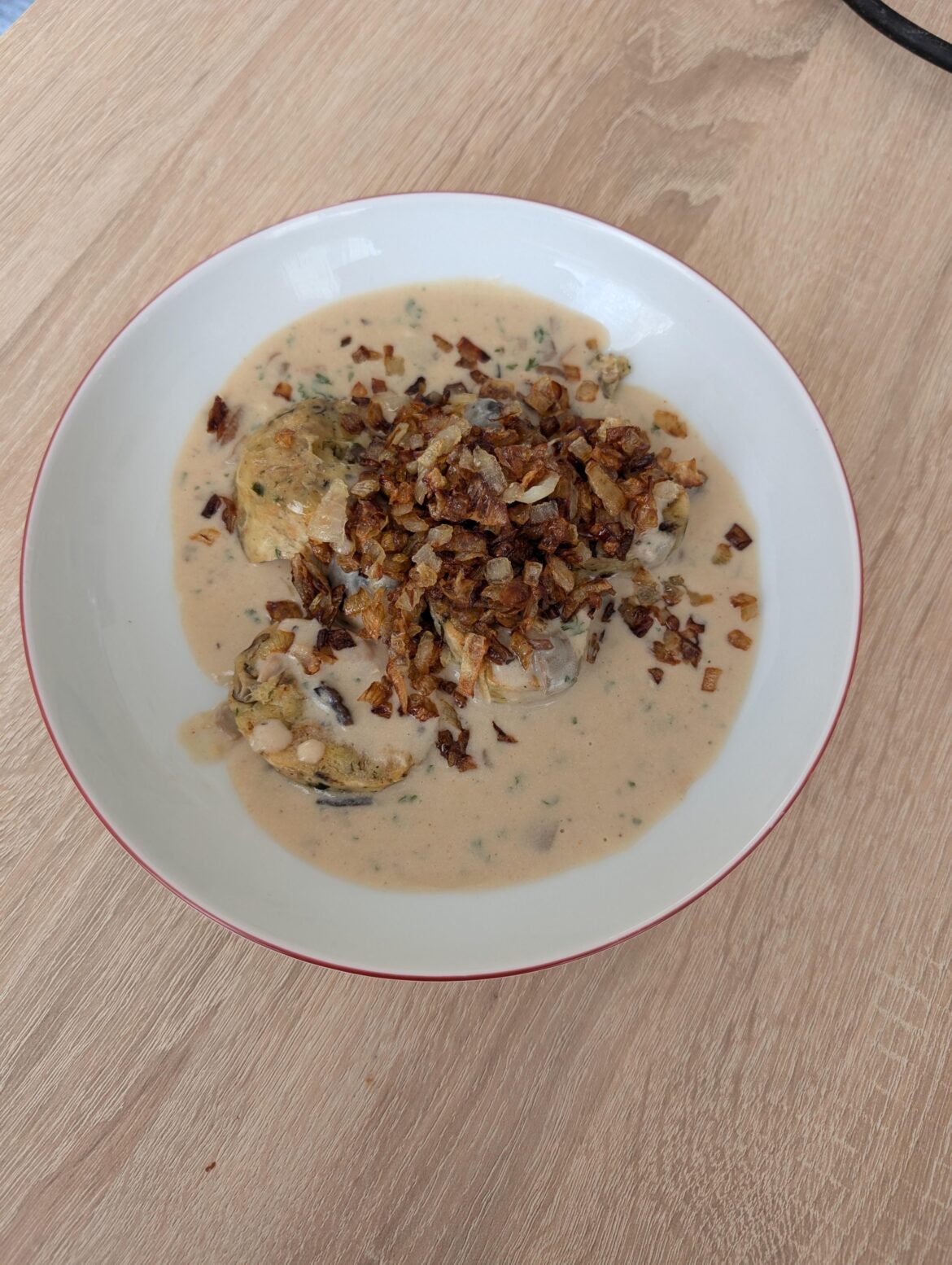 Mushroom knödel with creamy mushroom sauce and fried onion