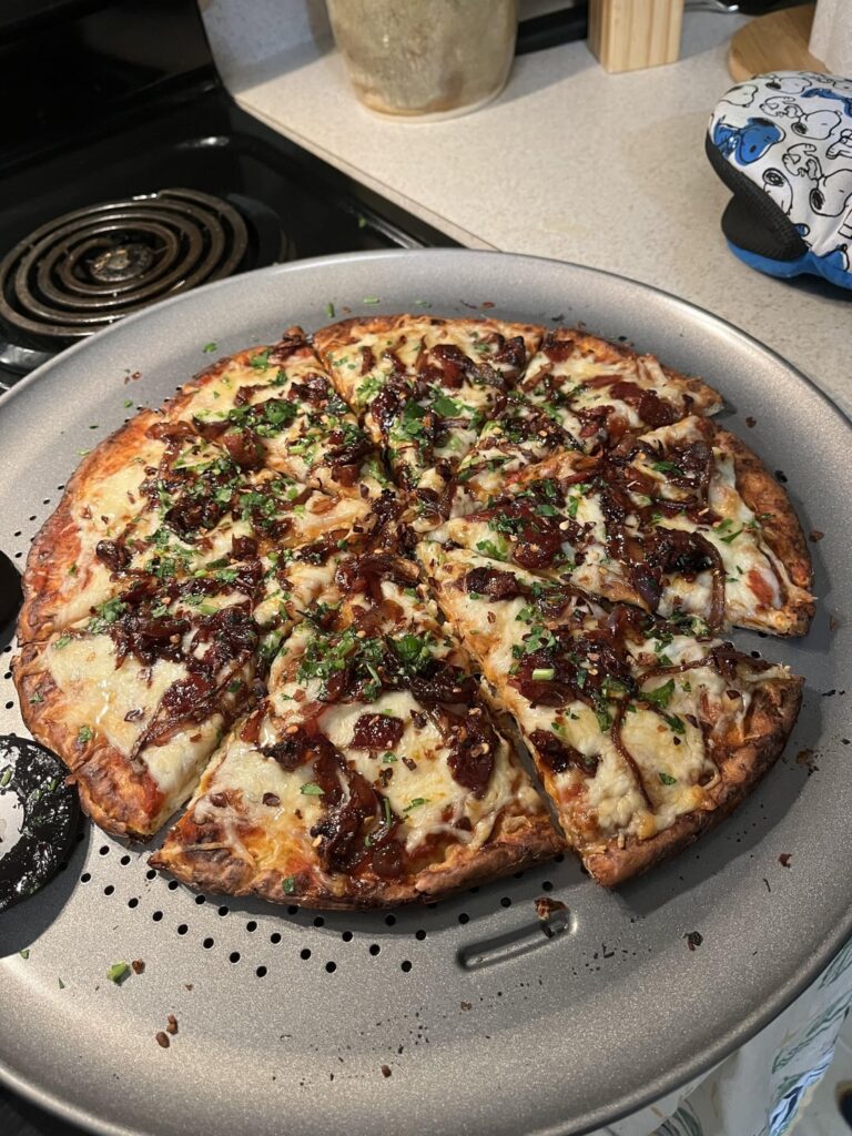 my lovely partner and i made some pizza with maple syrup covered bacon and onion