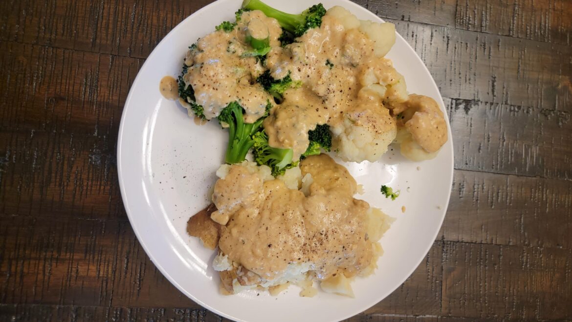 Steamed broccoli and cauliflower with baked potato smothered in "forbidden cheese"