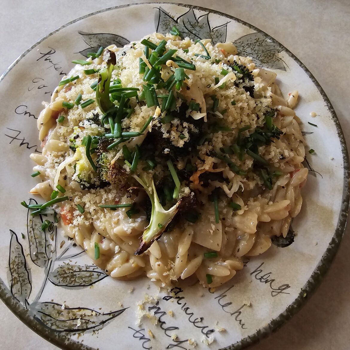 Orzo in a creamy red pepper sauce, topped with roasted parmesan broccoli, toasted bread crumbs and chives.