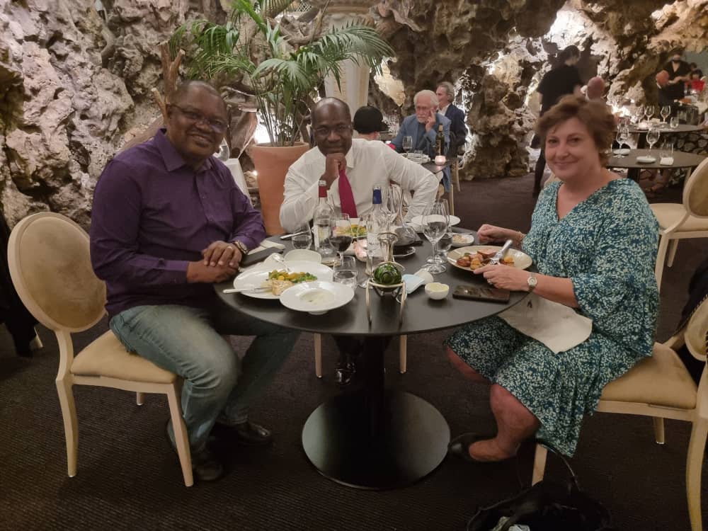 Three people seated at a restaurant table.