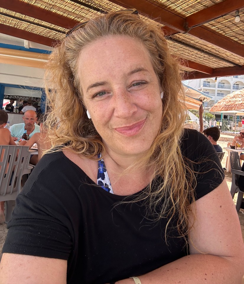 a woman in a black shirt smiles for the camera