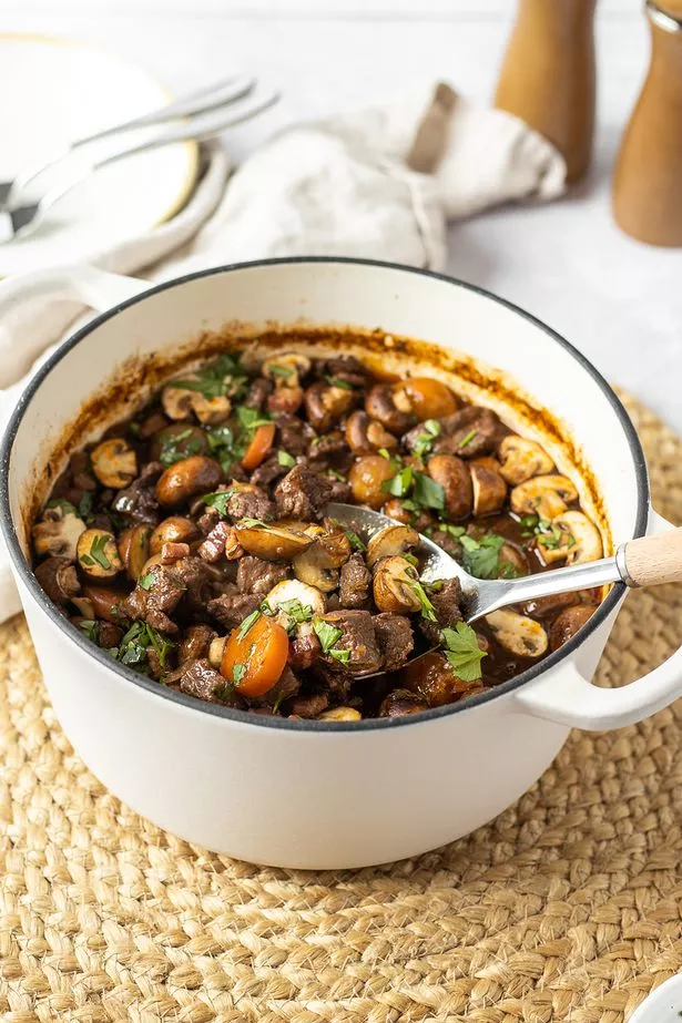 A picture of a beef bourguignon in a white le creuset-style pan