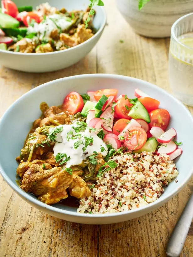 A picture of a lamb rogan josh served with rice, yoghurt and a salad