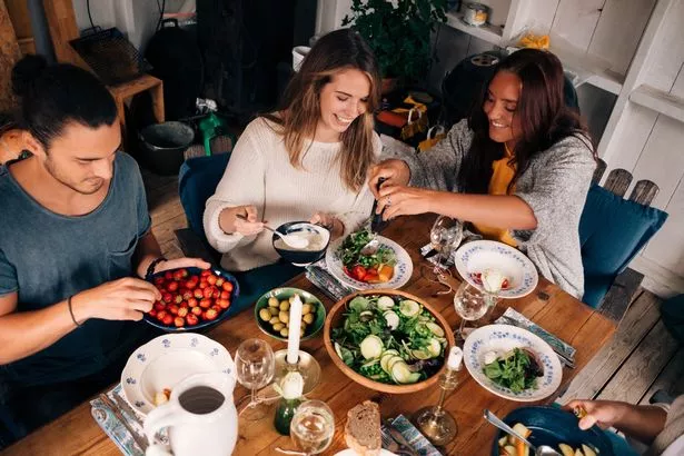 A stock shot of friends sitting round the table enjoying a meal together
