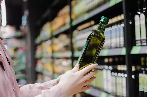 Woman choosing natural olive oil or grape seed oil at store. Concept of healthy food, bio, diet.