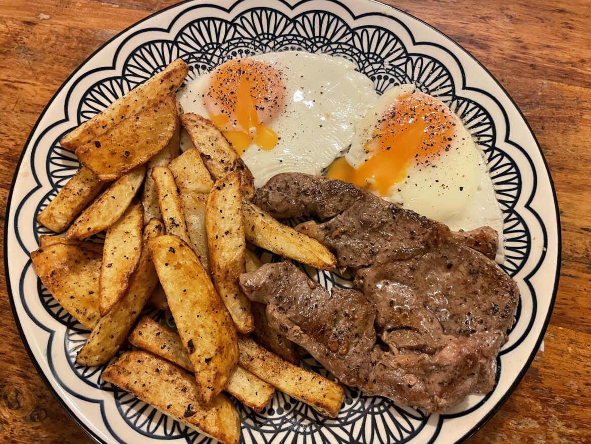 Lamb steak, homemade chips and fried eggs.