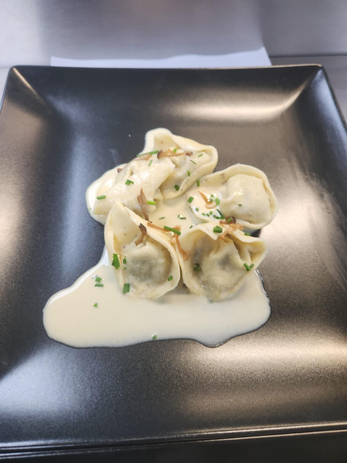 Mushroom tortellini served with a white wine creamy sauce topped with chive and crispy wild Mushrooms