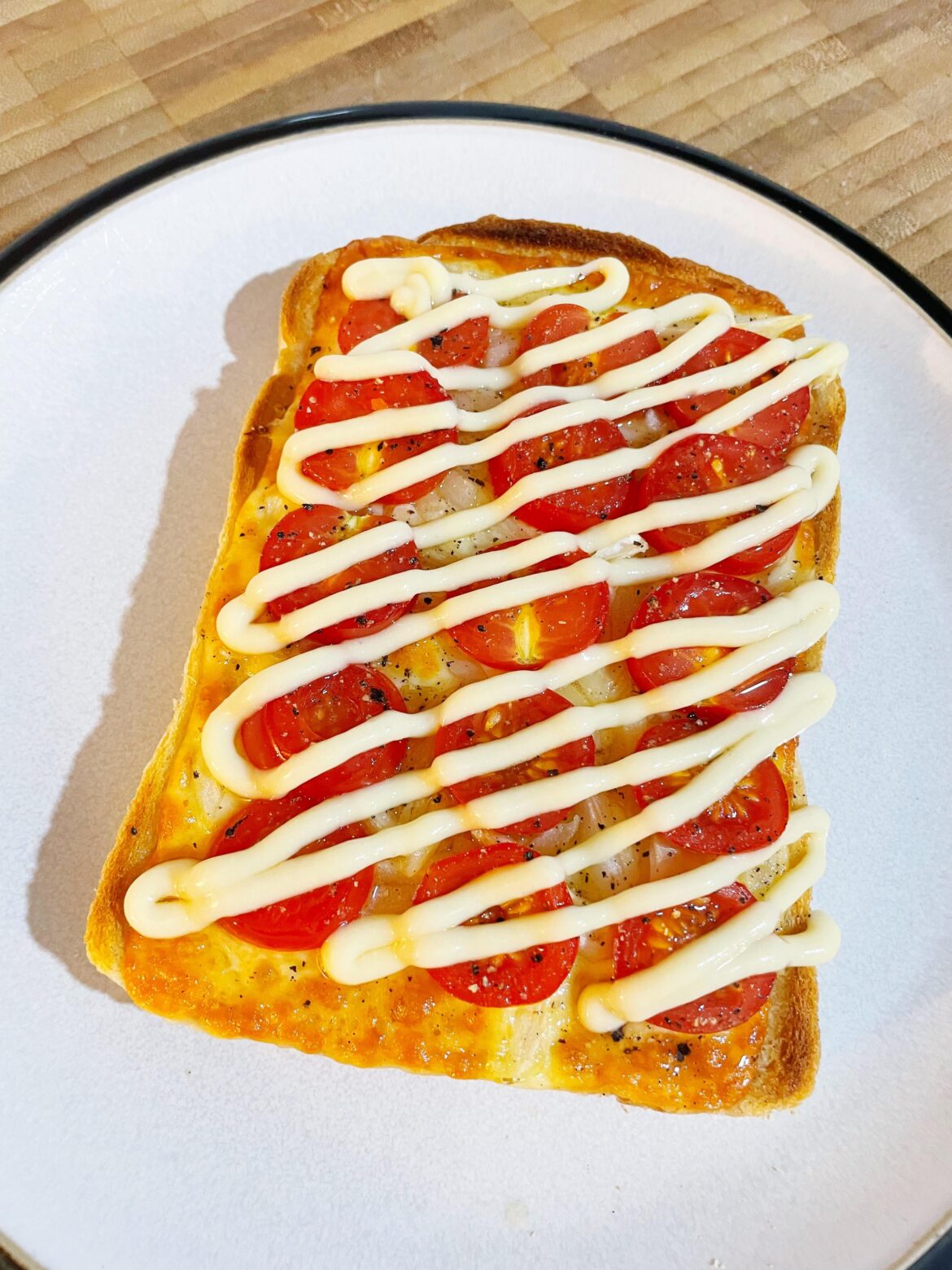 Cheese & Onion on toast topped with cherry tomatoes, cracked black pepper and salad cream drizzle