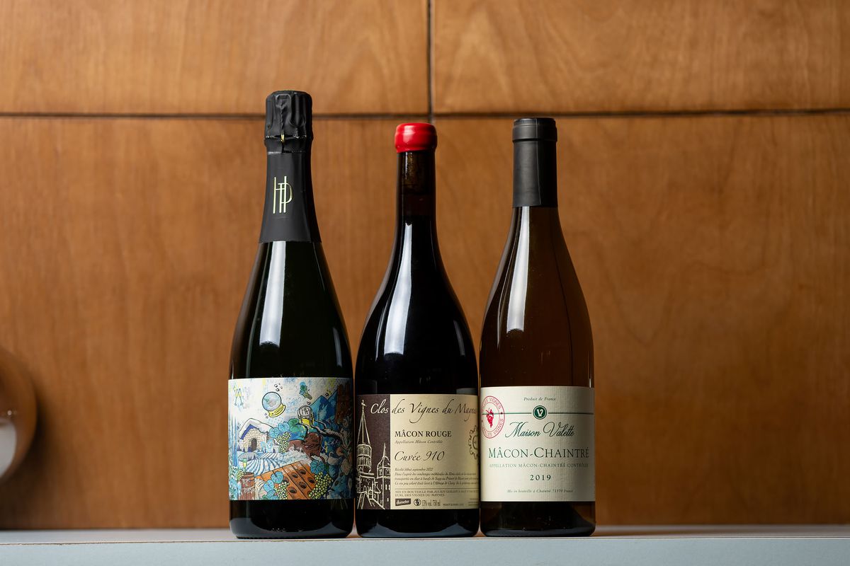 Three wine bottles set on a white counter at Bar Etoile. 