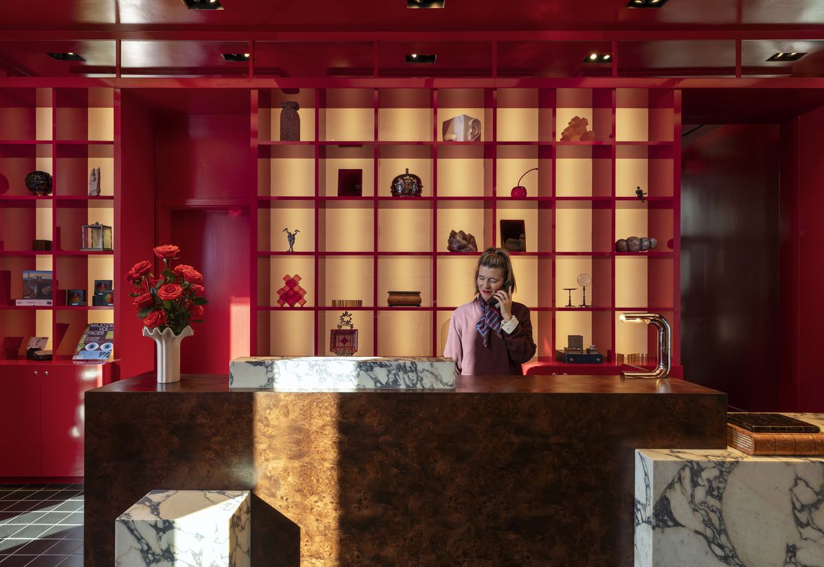 A person answers the phone in Hotel Saint Augustine’s bright red lobby.