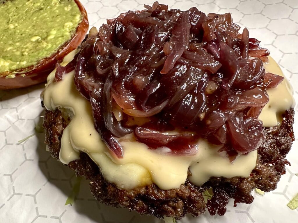 Smash burger with caramelized red onions and avocado