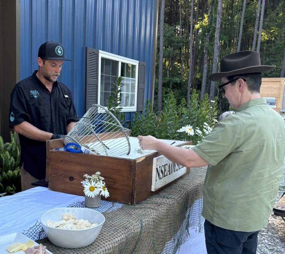 Conor MacNair (left) shucks oysters at N Sea Oyster Co. in Hampstead, N.C.