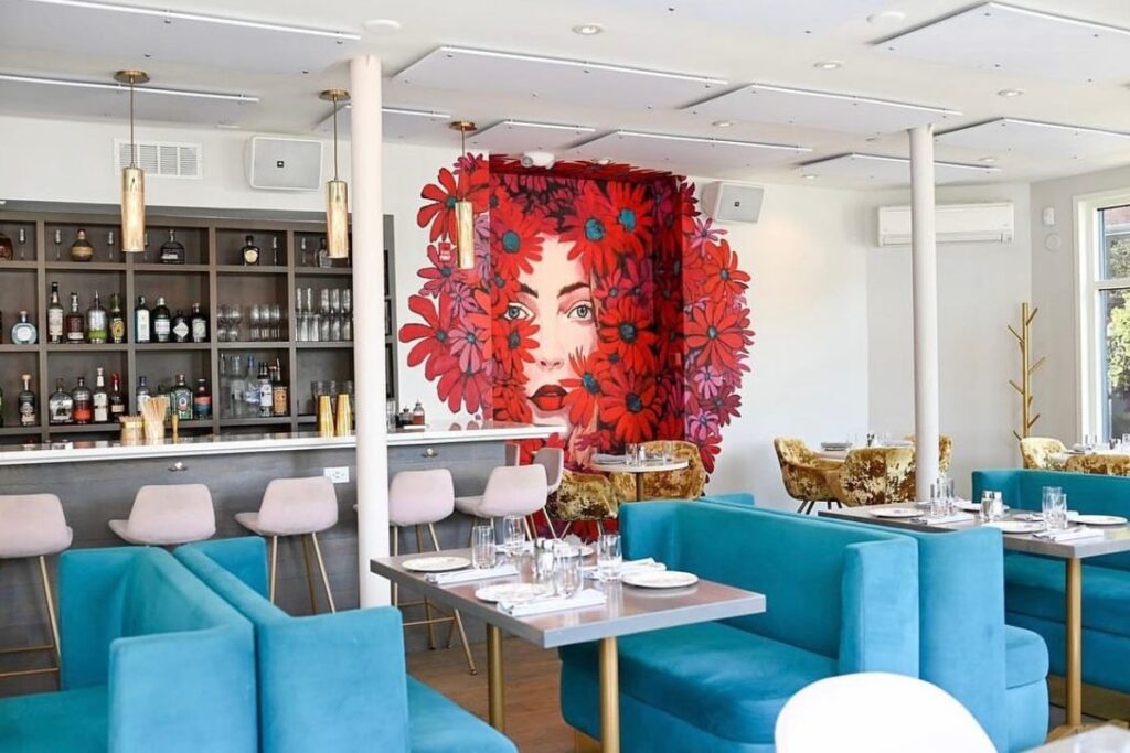 interior of ilona south end blue velvet couches and wall art
