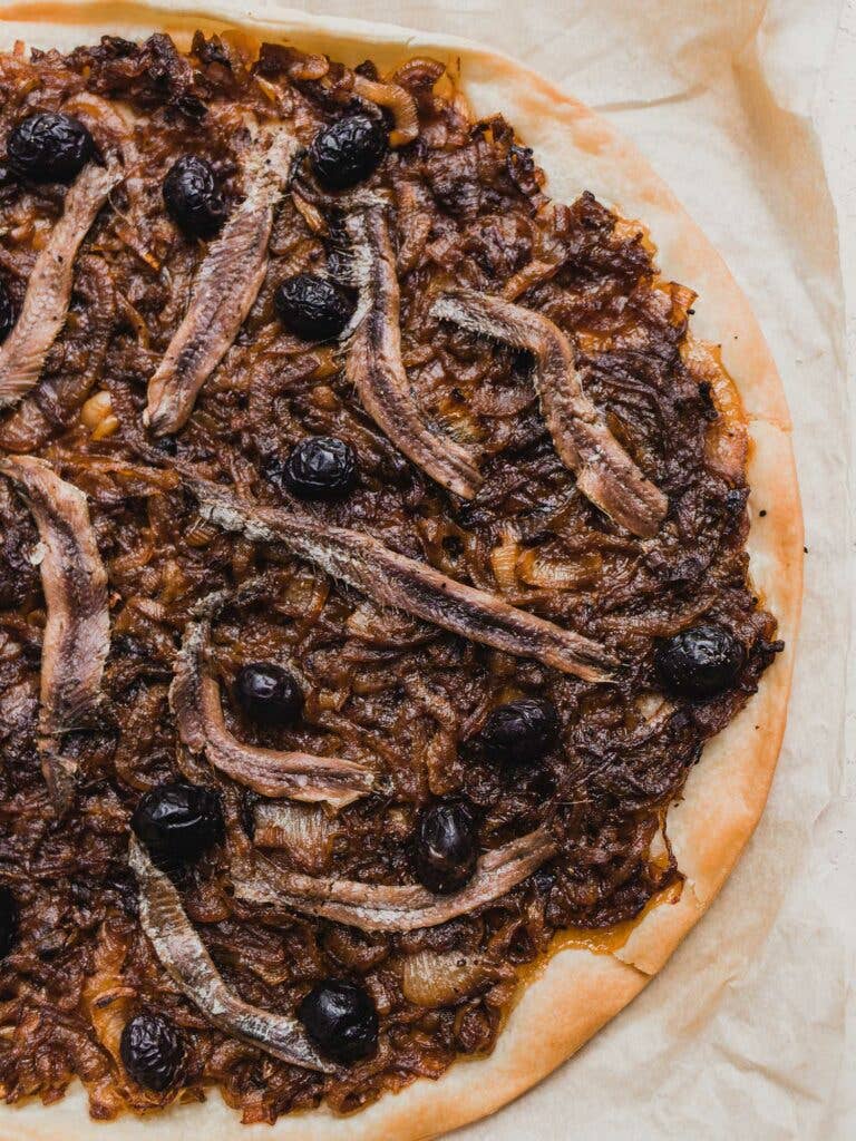 Yeast dough shaped in circle with umami-packed toppings.