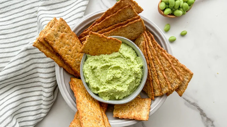 Bowl of edamame hummus and crackers for dipping