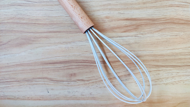 Whisk sitting on wooden table