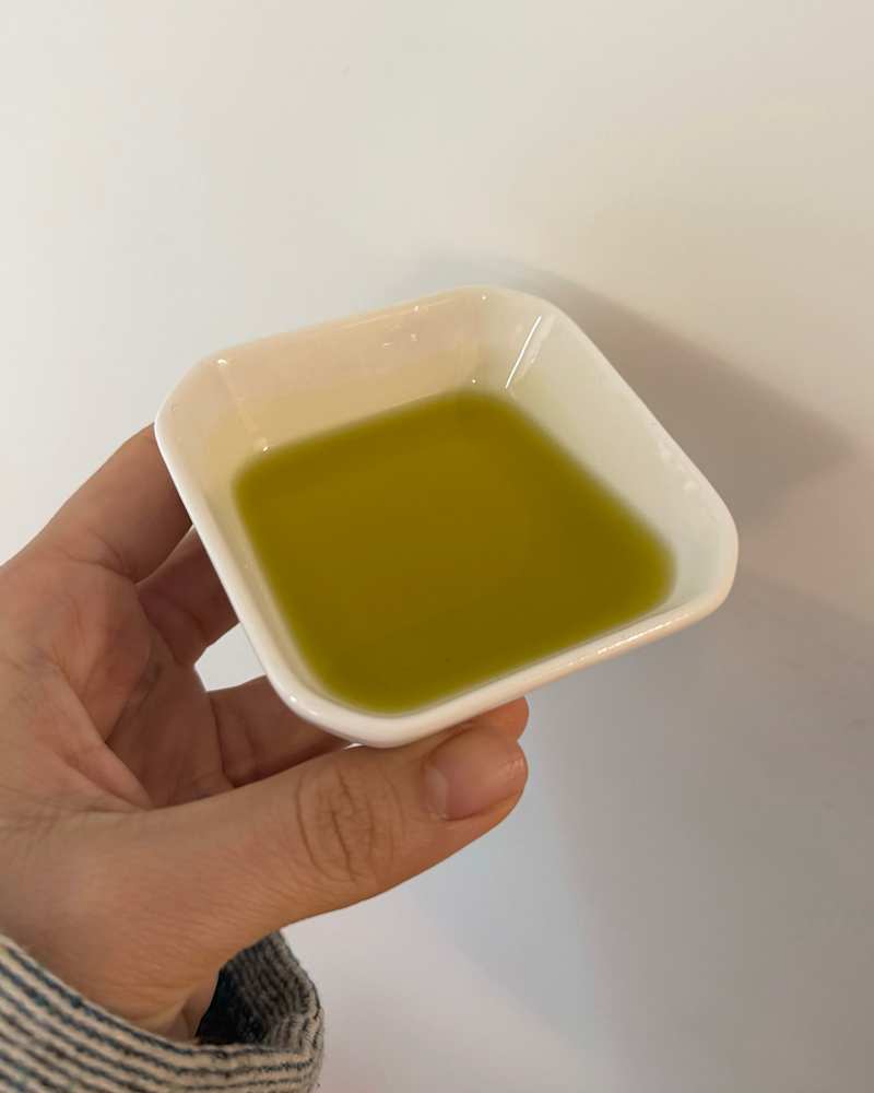 Someone holding a dish of Huwa Palestinian Extra Virgin Olive Oil
