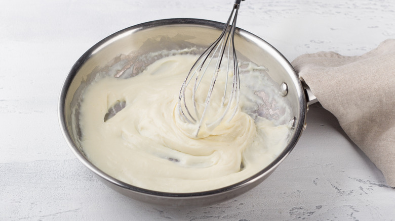 Béchamel sauce inside pan, with whisk