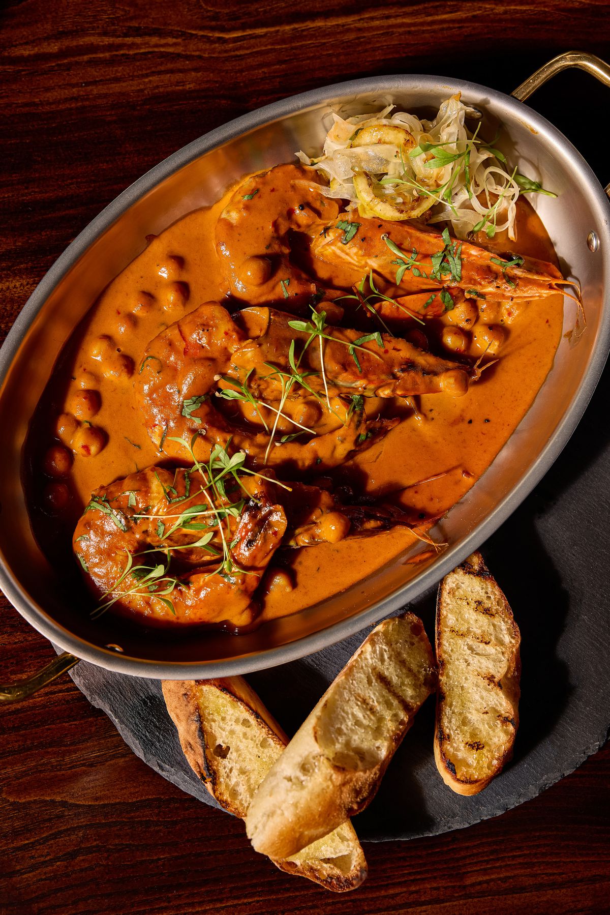 Moroccan tiger shrimp sit in a cream sauce with a side of grilled bread at Aris.