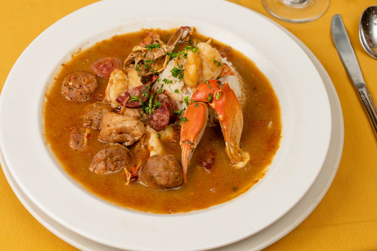 A bowl of gumbo on a yellow table