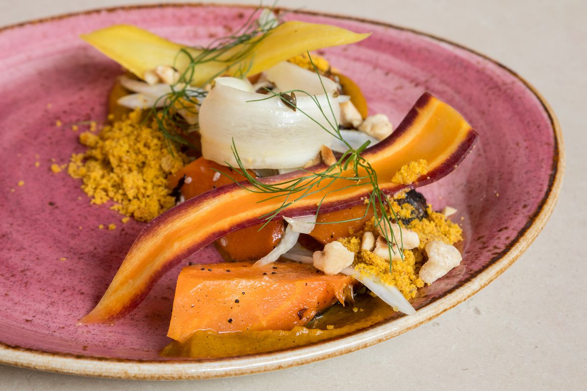 Shaved carrots with chunks of carrot and herbs.
