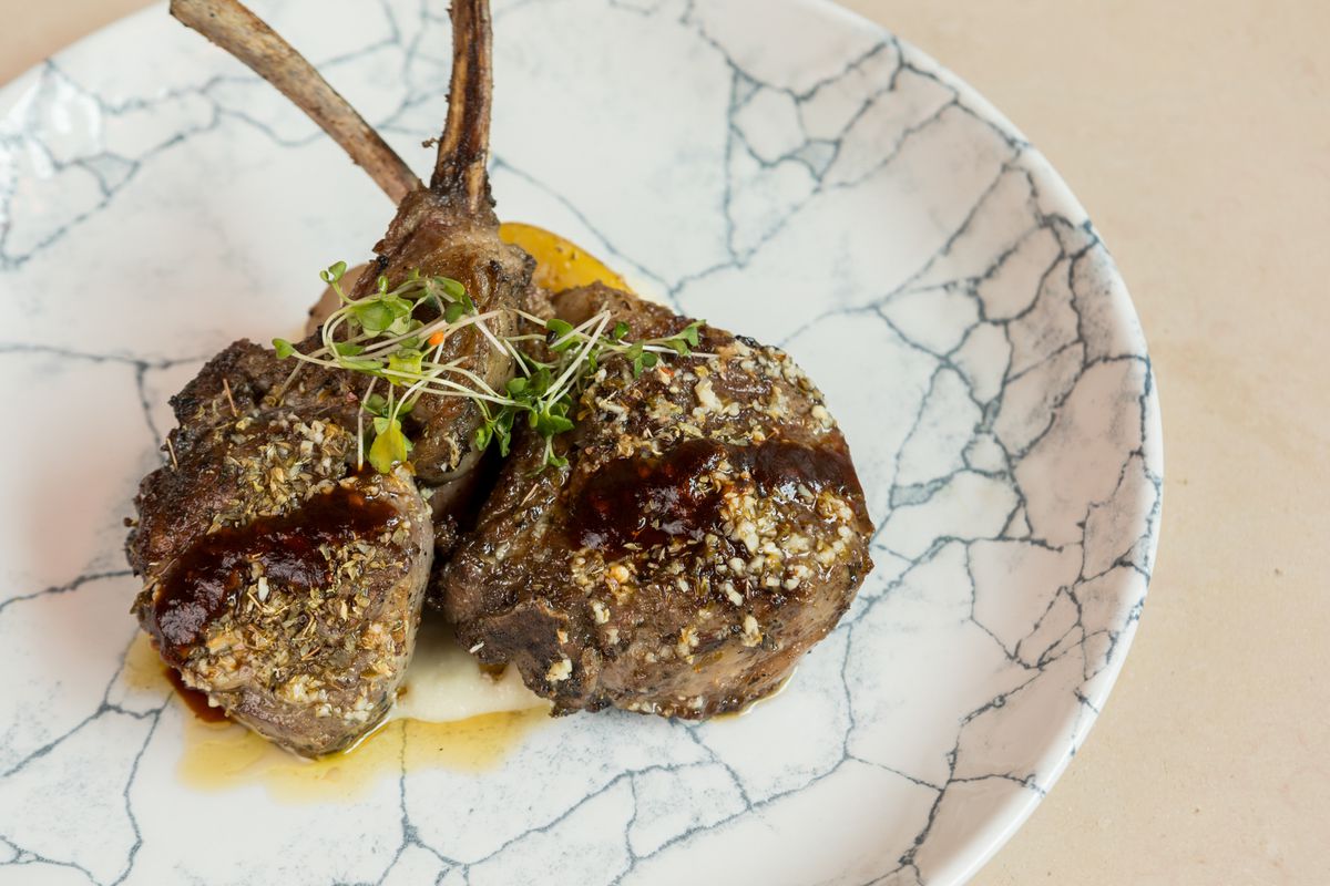 Two lamb chops on a marbled plate.