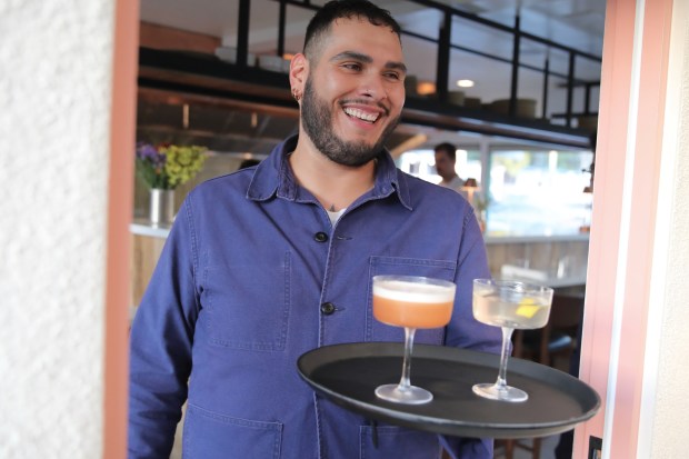 Chris Estrada serves cocktails with a smile on Friday, Oct....