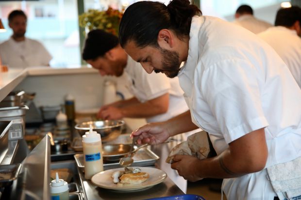Chefs prepare dishes on Friday evening, Oct. 4, 2024, at...