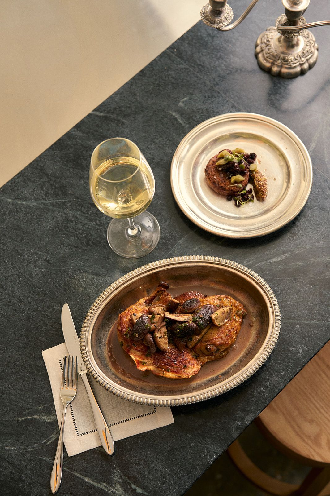 Half of a roast chicken on a silver platter.