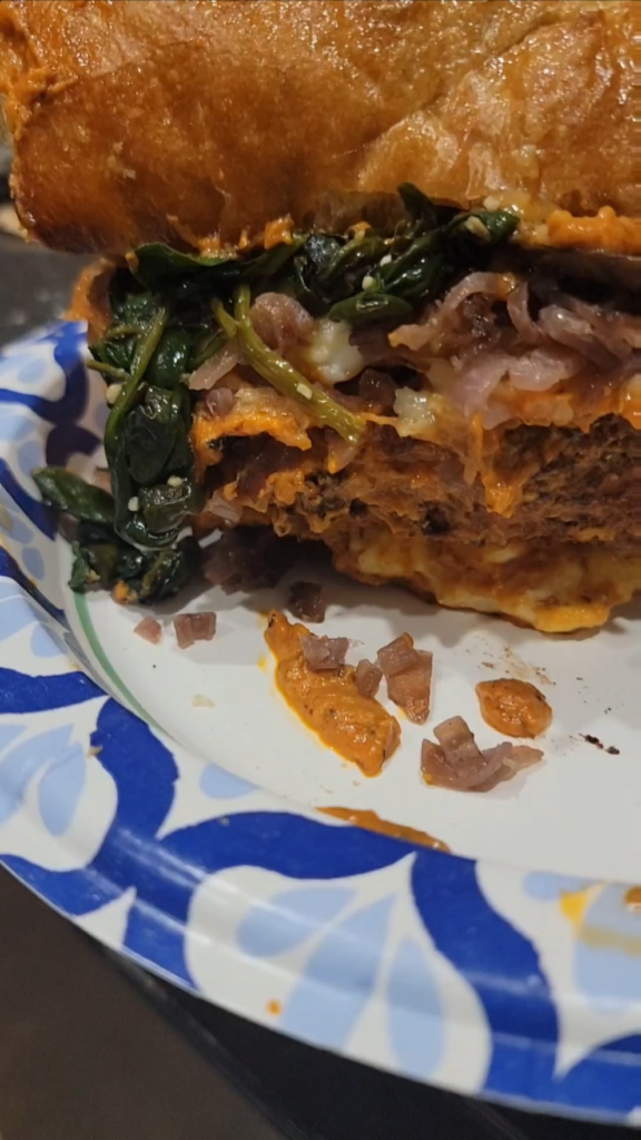 Behold, my deep fried ravioli smash burger drenched in homemade vodka sauce with fresh homemade cheesy garlic bread for the buns, and for the toppings spinach fried with garlic, and mushrooms and shallots that were bathed lightly in red wine and then also sautéed