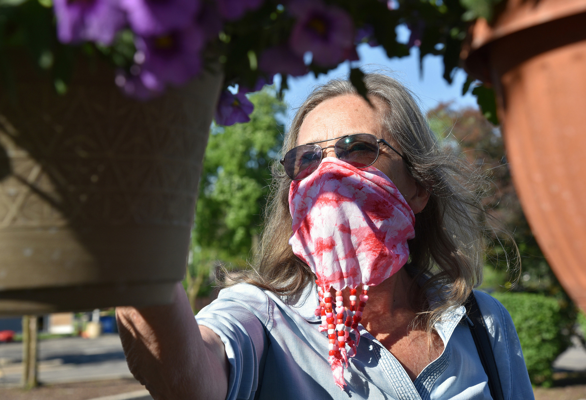 Carol Macejak, a Morton Grove resident, shops for hanging flower baskets. Images from the opening day of the Morton Grove French Market in Morton Grove on June 6, 2020 at 6140 Dempster St.