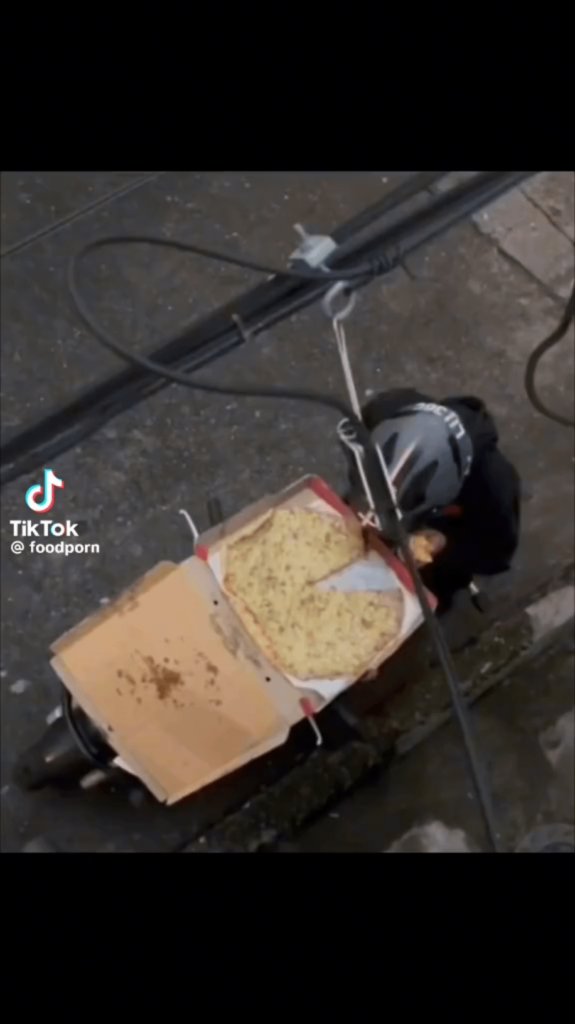 Pizza scooter delivery guy eating on the job!