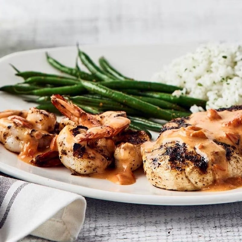 serving of grilled shrimp and chicken with vegetables and rice