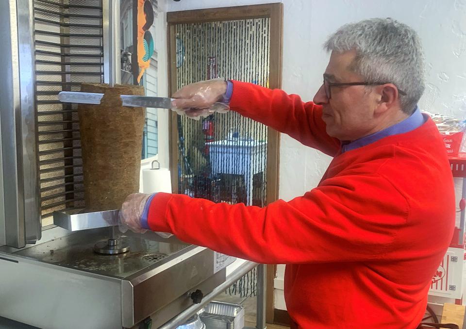 Kadir Yavuz slices gyro meat at Turquoise Sweets, a new restaurant he and his wife own on Madison Avenue in Elmira.